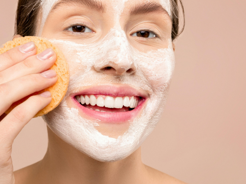 Woman facing the camera while applying a face mask — highlighting the ease and precision of face maskk